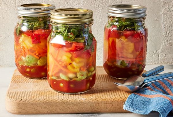Side view photo of 3 jars of Anti-Inflammatory Eat-the-Rainbow soup after broth is added with lid on top. Credit: Photographer: Jen Causey, Food Stylist: Emily Nabors Hall , Prop Stylist: Shell Royster