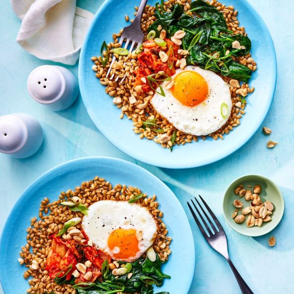 a recipe photo of the Wilted Spinach and Fried Egg Wheat Berry Bowl Credit: Photographer: Antonis Achilleos, Prop Stylist: Shell Royster, Food Stylist: Ruth Blackburn