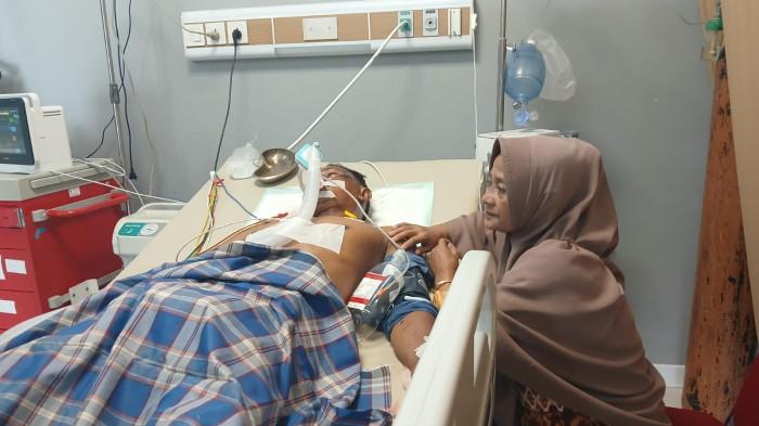 DIRAWAT - Nuraini, istri dari korban kecelakaan di Jalan MH Thamrin, Kecamatan Siantan setia menemani suaminya yang sedang kritis dalam perawatan di rumah sakit.