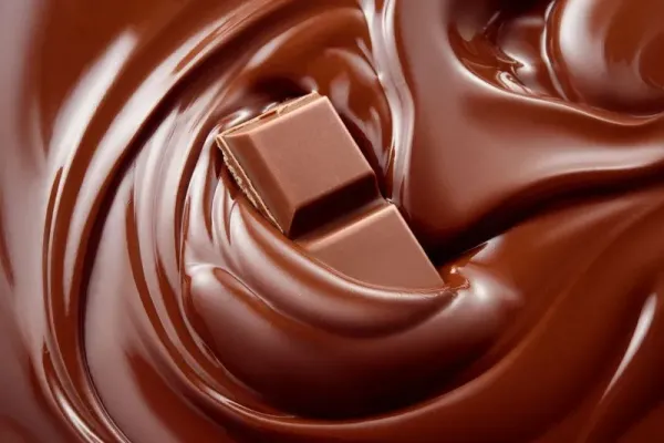 695585506 Chocolate bar in wine glass on background