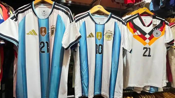 SAMBUT PESTA BOLA - Nofi Setiawan penjual jersey negara yang berlaga di Piala Dunia 2026 sedang memamerkan barang dagangannya di Mojosongo, Solo, Rabu (10/6/2026). Update ranking FIFA 48 peserta Piala Dunia 2026, Argentina kukuh di puncak, Ghana naik signifikan.