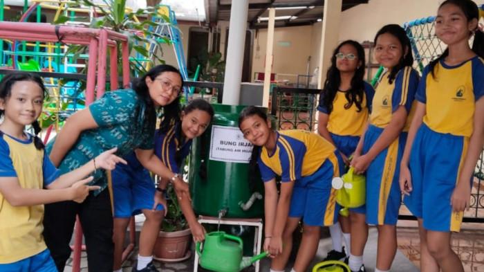 TABUNG AIR HUJAN - Foto para siswa dan guru SD di Kanisius Keprabon 01 yang sedang menyiram tanaman dengan Tabung Air Hujan (Bung Irjan) pada Rabu (15/4/2026).