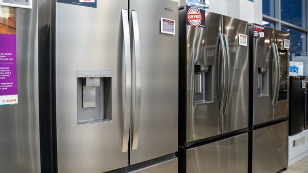 Several refrigerators lined up inside a store.