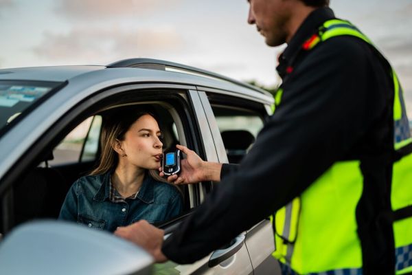 Young woman doing driver alcohol test on street
