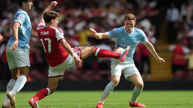 Pemain Arsenal Christos Tzolis (tengah) dan pemain Manchester City Elliot Anderson (kanan) berebut bola dalam laga final FA Community Shield antara Arsenal vs Manchester City di Cardiff, Wales, Minggu, 16 Agustus 2026. (AP Photo/Alastair Grant)