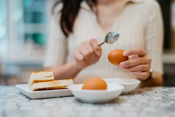 Image of a young Chinese woman having traditional style Malaysian breakfast in restaurant
