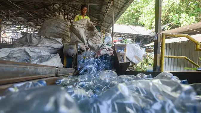 Pekerja mengolah sampah botol kemasan menjadi cacahan sebagai bahan biji plastik di Koperasi Pemulung Berdaya atau Recycle Business Unit (RBU) Tangerang Selatan, Tangerang, Banten, Rabu (30/7/2025). (merdeka.com/Arie Basuki)