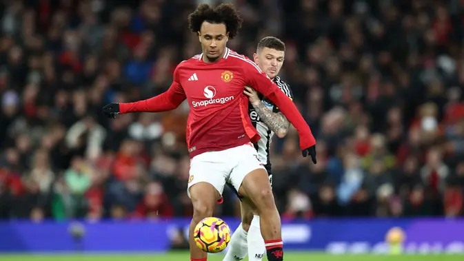 Manchester United vs Newcastle Bek Newcastle United asal Inggris #02, Kieran Trippier (Kanan), beradu dengan penyerang Manchester United asal Belanda #11, Joshua Zirkzee, selama pertandingan Liga Primer Inggris antara Manchester United dan Newcastle United di Old Trafford di Manchester, Inggris barat laut, Selasa dini hari WIB (31-12-2024). (Darren Staples/AFP)