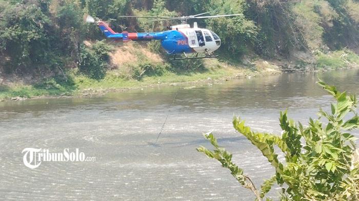 HELIKOPTER AMBIL AIR - Proses pengambilan air dengan helikopter untuk pemadaman api TPA Putri Cempo Solo, di Sungai Bengawan Solo, Kabupaten Karanganyar, Jumat (4/9/2026). Helikopter itu mampu mengangkut sekitar 9.000 liter air dalam sekali penerbangan.