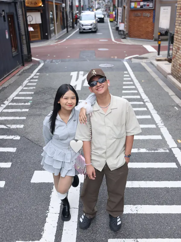 Itab dan April di Jepang (credit: instagram.com/da7_aprillll) Foto lain memperlihatkan April dan Itab berpose ceria di depan deretan vending machine minuman khas Jepang, mulai dari Coca-Cola hingga produk ITO EN. April berpose dengan tangan di dagu sambil tersenyum lebar, sementara Itab menunjukkan simbol peace dengan jarinya.<br><br>Keduanya tampak kompak mengenakan outfit senada dengan foto-foto sebelumnya, menunjukkan bahwa sesi foto ini berlangsung dalam satu rangkaian perjalanan yang sama. Momen sederhana di depan vending machine ini menjadi salah satu potret yang paling banyak dibagikan ulang oleh warganet.