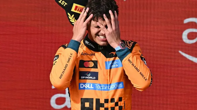 Pembalap McLaren asal Inggris, Lando Norris, bereaksi di atas podium saat upacara penyerahan trofi setelah menjuarai Formula 1 GP Hungaria di Sirkuit Hungaroring, Mogyoród, dekat Budapest, Hungaria, Senin (27/7/2026) pagi WIB.  (Attila Kisbenedek/AFP)
