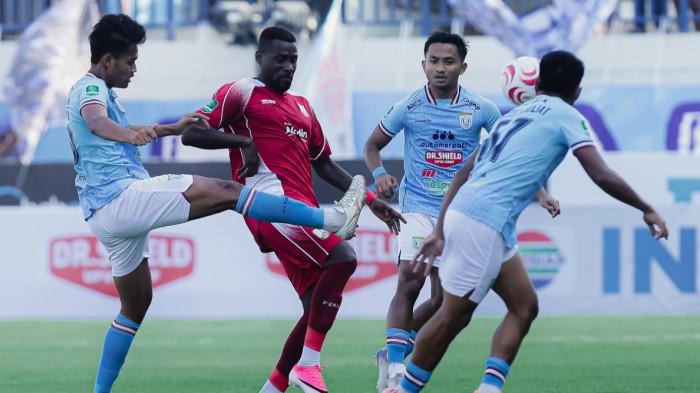 BERDUEL - Aksi penyerang Persis Solo, Henri Doumbia berusaha melepaskan diri dari hadangan para pemain Persela Lamongan pada pekan pertama Liga 2 Championshop 2026/2027 di Stadion Surajaya, Lamongan, Minggu (13/9/2026) sore WIB.