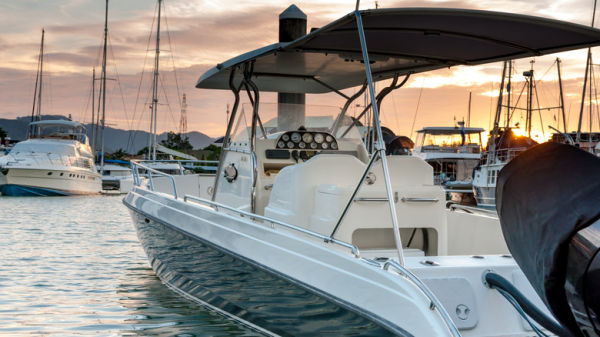 Boat docked at marina during sunset with other boats in the background