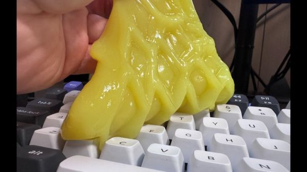 A close up shot of ColorCoral dust cleaning gel being used on a keyboard