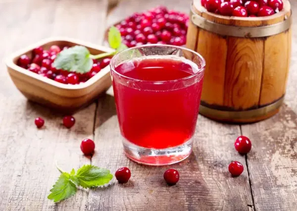 glass of cranberry juice with fresh berries on wooden table