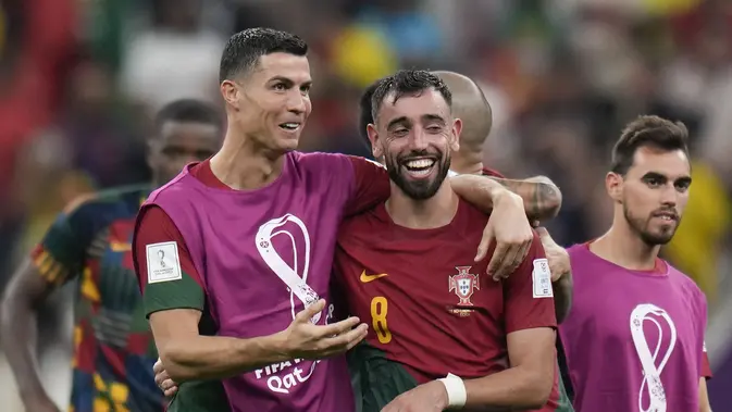 Cristiano Ronaldo dan Bruno Fernandes merayakan kemenangan Portugal 2-0 atas Uruguay pada pertandingan Grup H Piala Dunia 2022 di Lusail Iconic Stadium, Lusail, Qatar, Selasa, 29 November 2022. (AP Photo/Aijaz Rahi)