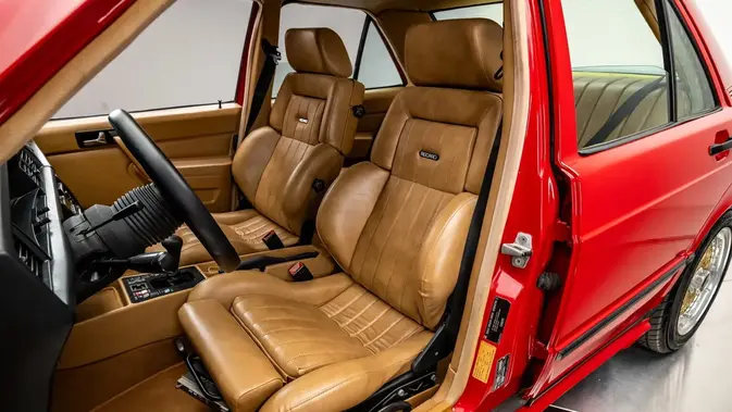 Suasana kabin Mercedes-Benz 190E Callaway yang tampil elegan dengan balutan jok sport Recaro berwarna Palomino serta setir MOMO kustom.