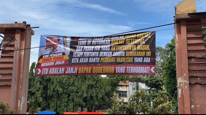 RELOKASI PASAR TAMAN PURING - Spanduk yang dipasang pedagang di lokasi kebakaran Pasar Taman Puring, Kebayoran Baru, Jakarta Selatan, Senin (25/5/2026). Mereka menagih janji revitalisasi yang pernah disampaikan Gubernur DKI Jakarta Pramono Anung, sambil menunggu kepastian relokasi maupun pembangunan kembali pasar.