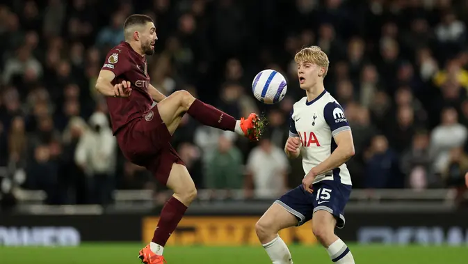 Gelandang Kroasia Manchester City Mateo Kovacic berebut bola dengan gelandang Tottenham Hotspur asal Swedia Lucas Bergvall selama pertandingan sepak bola Liga Primer Inggris antara Tottenham Hotspur dan Manchester City di Stadion Tottenham Hotspur di London, pada 26 Februari 2025.Adrian Dennis / AFP