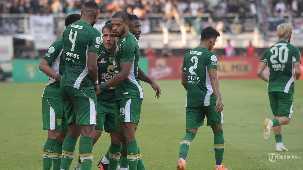 BERAKHIR IMBANG - Pencetak dua gol untuk Persebaya Miguel (11) dikerumuni rekan satu tim usai mencetak gol pertama ke gawang PSS Sleman  pada laga yang berlangsung di Stadion Gelora Bung Tomo (GBT) Surabaya, Minggu (18/10/2026). Pada pertandingan pekan ke #5 ini Persebaya hanya mampu menahan imbang PSS Sleman dengan skor akhir 2-2. SURYA/HABIBUR ROHMAN